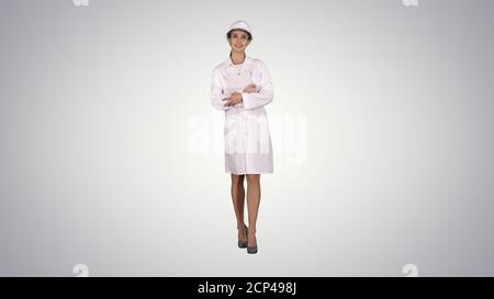 Female doctor engineer walking with digital tablet on gradient b Stock Photo
