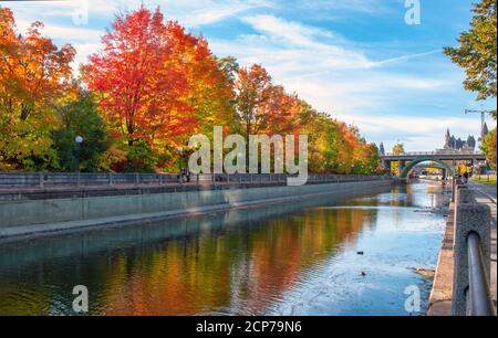Beautiful autumn foliage and reflections along Rideau Canal and pathway in Ottawa, Ontario, Canada Stock Photo