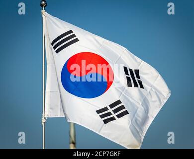 The flag of South Korea blowing in the wind at the Demilitarized Zone, with a clear blue sky in the background Stock Photo