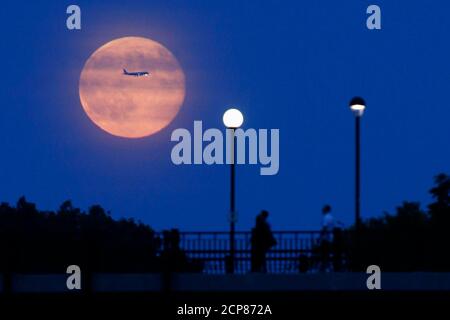Aircraft passes in front of a Supermoon rising over the Rideau Canal in Ottawa July 12, 2014. Occurring when a full moon or new moon coincides with the closest approach the moon makes to the Earth, the Supermoon results in a larger-than-usual appearance of the lunar disk.    REUTERS/Blair Gable (CANADA - Tags: SOCIETY TRANSPORT ENVIRONMENT TPX IMAGES OF THE DAY)