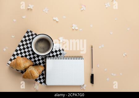 Morning cup of coffee, empty notebook, snacks and hydrangea flowers. Top view, flat lay. Stock Photo