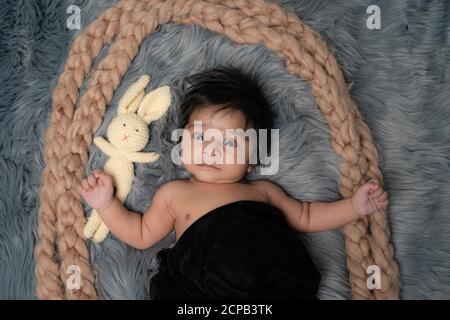 baby on grey background close-up, different emotions, design element, space for text, with teddy Stock Photo