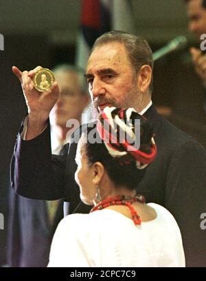 Cuban President Fidel Castro Holds Up A Booklet On The Relations Of Latin America And The Caribbean Nations During The Day S Morning Session Of The Xxiv Latinamerican Economic System Conference Sela December