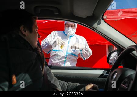 Drive-in for corona virus test, at the mobile test station a doctor takes a smear through the car window (posed scene), Kempen, Lower Rhine, North Stock Photo