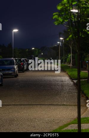 Street lights on a road showing lampposts switched on in a quiet residential road in West Sussex, England, UK. Stock Photo
