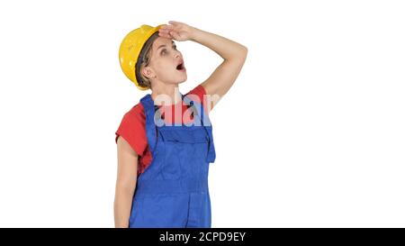 Engineer construction worker woman looking up amazed on white ba Stock Photo