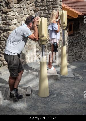 SZIGLIGET, HUNGARY - 08/26/2020: Visitors watching 3D animation of medieval castle ruins of Szigliget. Stock Photo