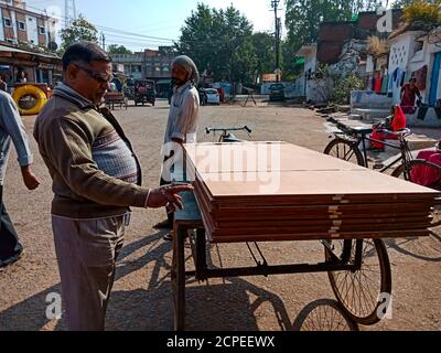 DISTRICT KATNI, INDIA - JANUARY 08, 2020: An indian man inspecting plywood during transportation on road. Stock Photo