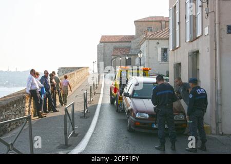 Two policemen prescribed fine fee for wrong parking on the street.  The car will be towed. Stock Photo