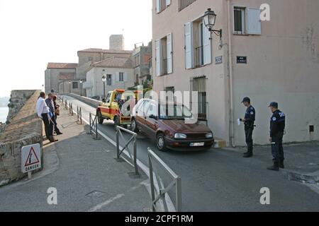 Two policemen prescribed fine fee for wrong parking on the street.  The car will be towed. Stock Photo