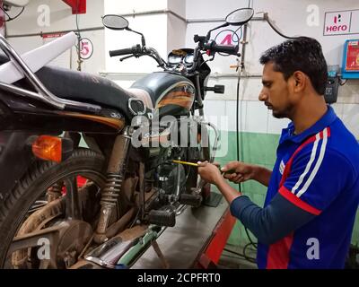 DISTRICT KATNI, INDIA - JANUARY 18, 2020: Indian automobile engineer repairing bike engine at Hero motorcycle workshop. Stock Photo