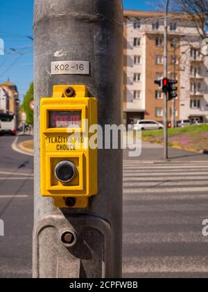 Pedestrian traffic light button for calling green walk sign.(Translation of inscriptions: ČEKEJTE = WAIT, TLAČÍTKO PRO CHODCE = BUTTON FOR Stock Photo