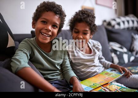 Male and female child sitting and holding pcture book Stock Photo