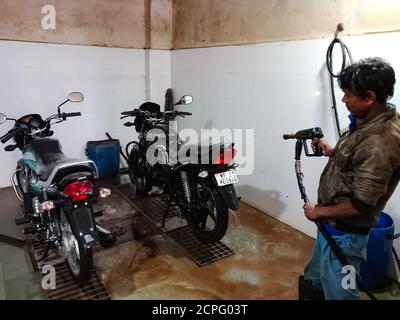 DISTRICT KATNI, INDIA - JANUARY 18, 2020: Indian automobile male worker washing bikes at Hero motorcycle workshop. Stock Photo