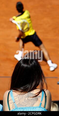 A Woman With A Tattoo Watches As Novak Djokovic Of Serbia Hits A Return To Fernando Verdasco Of Spain During Their Quarter Final Match At The Rome Masters Tennis Tournament In Rome April