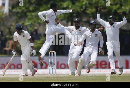 Sri Lanka's Tharindu Kaushal (2nd L) celebrates with his teammates Lahiru Thirimanne (C), Dinesh Chandimal (2nd R) and captain Angelo Mathews (R) after taking the wicket of India's captain Virat Kohli (L) during the fourth day of their first test cricket match in Galle August 15, 2015. REUTERS/Dinuka Liyanawatte