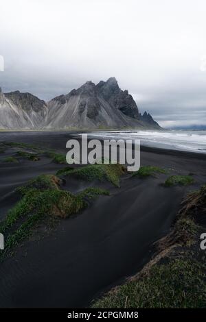 Aerial view of Vestrahorn mountain and the coastal road winding through ...