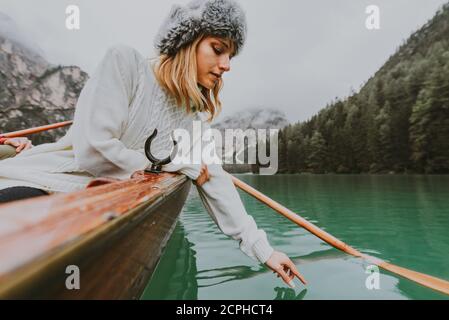 Beautiful woman visiting an alpine lake at Braies, Italy - Tourist with hiking outfit having fun on vacation during autumn foliage - Concepts about tr Stock Photo