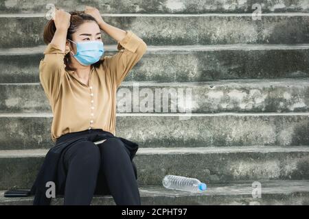 depressed unemployed Asian business woman wearing protective mask loosing her job caused  Coronavirus Covid-19 pandemic ,business crisis 2020 Stock Photo