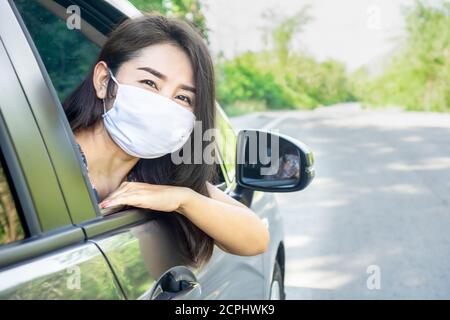 Asian woman wearing protective mask sitting in a car new normal lifestyle concept