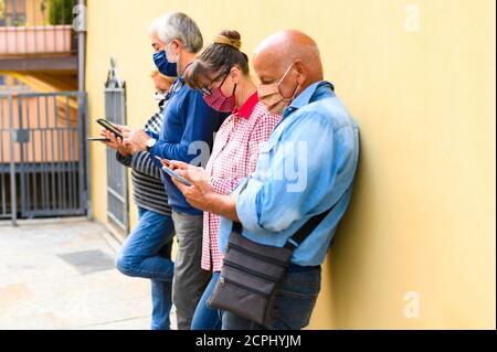 Group of senior friends watching smart mobile phones - Retired  friends addiction to new technology trends - Concept of elderly, tech, social Stock Photo