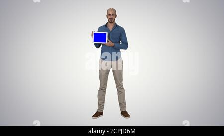 Smiling casual man presenting a tablet with a blank screen on gr Stock Photo