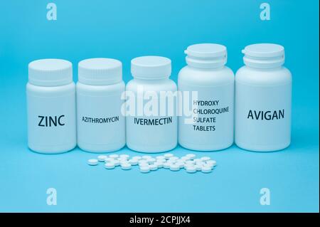 Medicine bottles for COVID-19 treatments. Scattered pills. isolated on blue background. Stock Photo