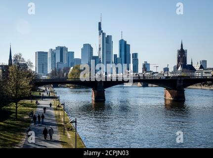 People walk on the banks of the Main in front of the skyline of downtown Frankfurt with the banking district, Frankfurt am Main, Hesse, Germany Stock Photo