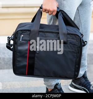 Young man holding a black sport bag close up Stock Photo