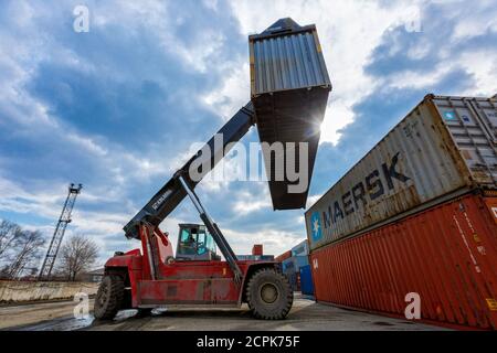 Container terminal. Large forklift lifts a metal container Stock Photo ...