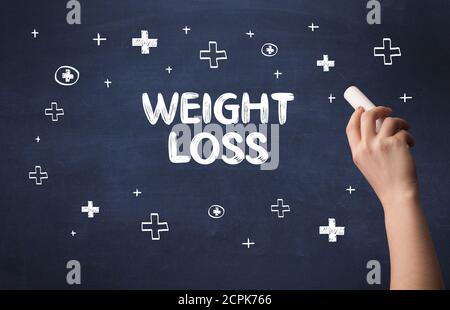 Hand drawing WEIGHT LOSS inscription with white chalk on blackboard, medical concept Stock Photo