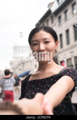 a chinese woman holding hands in love in old montreal quebec canada on an overcast day. Stock Photo