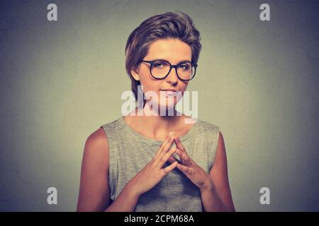 Closeup portrait of sneaky, sly, scheming young woman in glasses trying to plot something, screw someone isolated on gray background. Negative human e Stock Photo