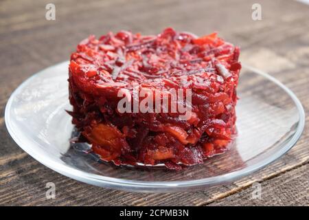 vegetarian salad of beets, carrots, garlic and olive oil on a plate is on the table Stock Photo