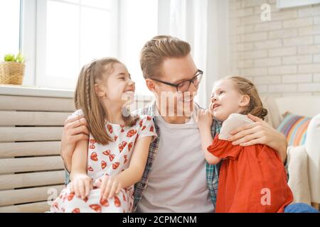 Happy loving family. Daddy and his daughters children girls playing together. Father's day concept. Stock Photo