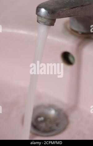 water flowing from faucet in bathroom Stock Photo