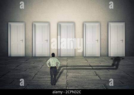 Making a choice opportunity concept. Businessman facing group of career opportunities with his cast shadow preferring or choosing one door entrance sy Stock Photo
