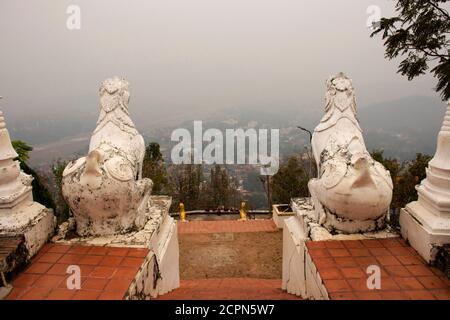 White singha statue guardian at Wat Phra That Doi Kong Mu Temple with landscape and cityscape of Maehongson hill valley city in Mae Hong Son, Thailand Stock Photo