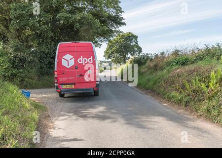 White DPD delivery van (Mercedes) with familiar red box on Cornish rural road. For rural delivery services in UK, parcel deliveries, courier services. Stock Photo