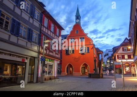 Twilight scene in the small town of Lahr in the Black Forest, Germany (province of Baden Wurttemberg) with focus on the red building of the Town Hall. Stock Photo