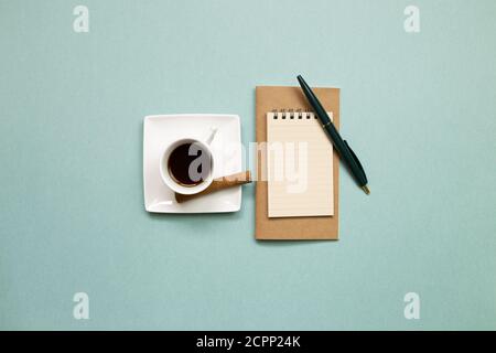 Notebook and black coffee on green background. flat lay, top view, copy space. Work and study place Stock Photo