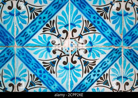 Old broken colourful vintage ceramic tiles wall background from Portugal. Blue, white and black pattern. Stock Photo