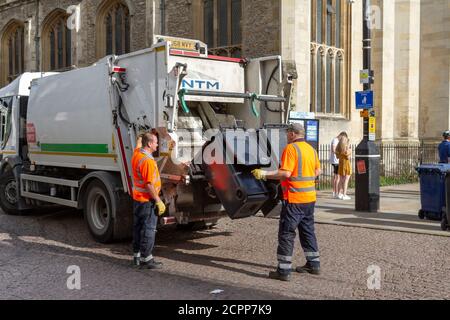 Wheelie bins being raised into a refuse truck on Kings Parade, Cambridge, Cambridgeshire, UK. Stock Photo