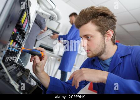 technician using a tablet to fix a printer Stock Photo