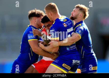 St Helens' Kevin Naiqama (second left) is tackled by Warrington Wolves' Joe Philbin (left) Jack Hughes and Matt Davis during the Betfred Super League match at the AJ Bell Stadium, Salford. Stock Photo