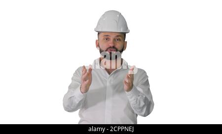 Engineer in a white helmet explaining something to camera on whi Stock Photo