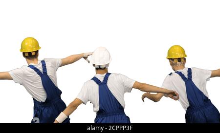 Three male construction workers in hard hats synch dancing with Stock Photo