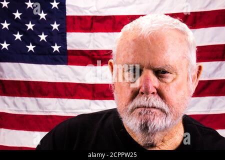 Suspicious Vietnam Vet Staring At Camera With American Flag Background Stock Photo