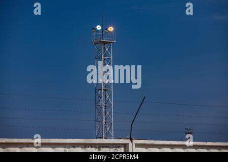 Lighting mast with floodlight at oil refinery plant against blue sky background.. Stock Photo