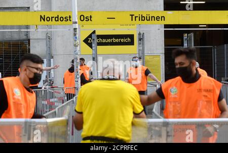Dortmund, Germany. 19th Sep, 2020. Football: Bundesliga, Borussia Dortmund - Borussia Mönchengladbach, 1st matchday at Signal Iduna Park. Folders wear mask and face shield at the stadium entrance. IMPORTANT NOTICE: In accordance with the regulations of the DFL Deutsche Fußball Liga and the DFB Deutscher Fußball-Bund, it is prohibited to use or have used in the stadium and/or from the game taken photographs in the form of sequence images and/or video-like photo series. Credit: Bernd Thissen/dpa/Alamy Live News Stock Photo